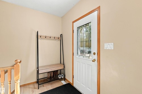 Entryway featuring a white door with decorative glass inserts, wood-finish flooring, and light-toned wall paint - 51064 Rge Rd 222, Rural Strathcona County, AB 