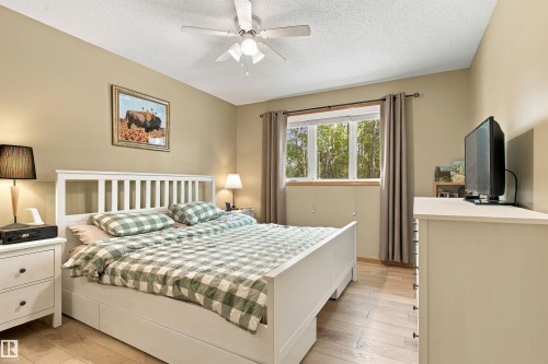 Wood-finish flooring with a white slatted headboard and built-in storage - 51064 Rge Rd 222, Rural Strathcona County, AB 