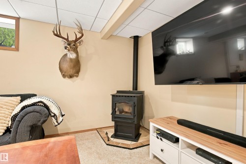 Freestanding fireplace with a tiled hearth and a wall-mounted television - 51064 Rge Rd 222, Rural Strathcona County, AB 