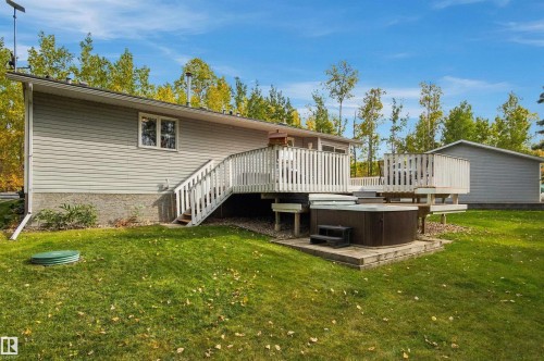Expansive rear deck with white railings, integrated hot tub, and exterior siding - 51064 Rge Rd 222, Rural Strathcona County, AB 