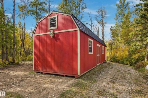 Red vertical siding with white trim, black metal roof, and upper-level window - 51064 Rge Rd 222, Rural Strathcona County, AB 