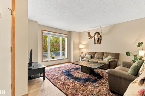Large windows offering ample natural light, neutral wall colors, and wood-finish flooring - 51064 Rge Rd 222, Rural Strathcona County, AB 