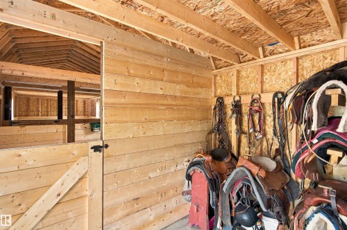 Wood-paneled interior walls, exposed wood beam ceiling, wood-framed barn stall door, structural wood framing, wood plank wall construction - 51064 Rge Rd 222, Rural Strathcona County, AB 
