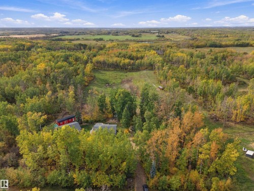 Expansive wooded property featuring a red outbuilding and a detached structure - 51064 Rge Rd 222, Rural Strathcona County, AB 