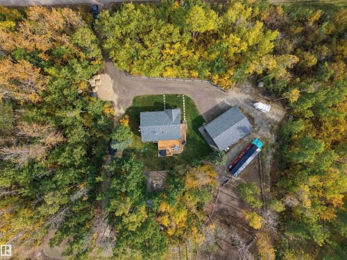 Private, treed parcel featuring a primary residence with a deck, a detached outbuilding, and a gravel driveway - 51064 Rge Rd 222, Rural Strathcona County, AB 