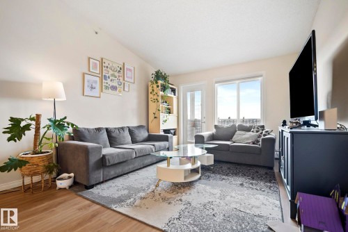 Vaulted ceiling, wood-finish flooring, white walls, and a built-in shelving unit - #416 111 Edwards Dr Sw, Edmonton, AB 