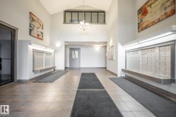 Tiled flooring entrance featuring a vaulted ceiling and integrated mailbox system - 