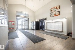 Spacious entryway featuring a vaulted ceiling, durable tile flooring, and integrated wall-mounted mailboxes - 