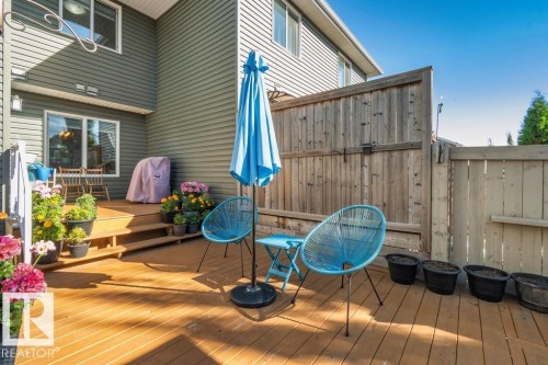 Multi-level wood deck featuring integrated stairs, vertical wood privacy fencing, and neutral-tone horizontal siding - 6818 Evans Wynd Nw, Edmonton, AB 