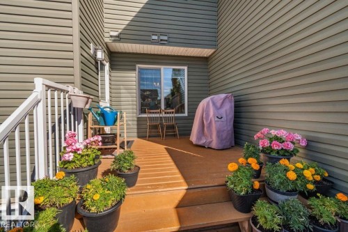 Exterior deck featuring composite decking, white metal railing, and horizontal vinyl siding - 6818 Evans Wynd Nw, Edmonton, AB 