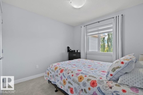 Neutral-toned interior walls, neutral wall-to-wall carpeting, and a double-pane window with white trim - 6818 Evans Wynd Nw, Edmonton, AB 