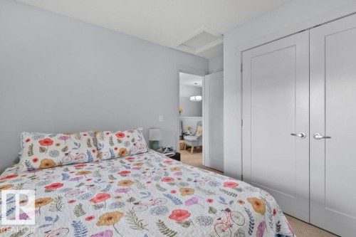 Room featuring neutral-toned walls, carpeting, and double-panel doors with satin nickel hardware - 6818 Evans Wynd Nw, Edmonton, AB 