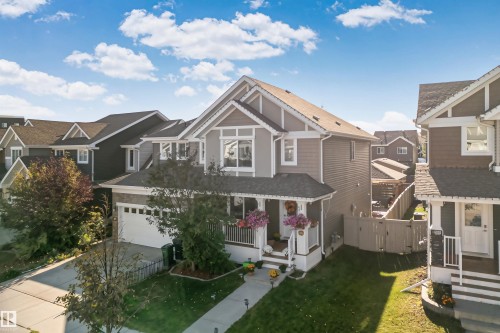 Two-story residence featuring lap siding, a front-facing gable roofline, an integrated two-car garage, and a covered front porch with railing - 6818 Evans Wynd Nw, Edmonton, AB 