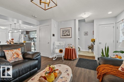 Interior space featuring wood-finish flooring, a geometric pendant light fixture, recessed lighting, and solid-core interior doors - 6818 Evans Wynd Nw, Edmonton, AB 