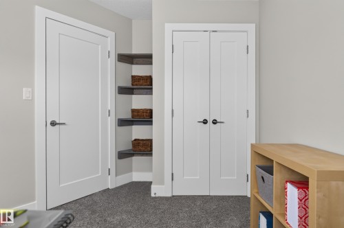 Shaker-style interior doors featuring matte black hardware, built-in corner shelving, and neutral wall color - 798 Berg Loop, Leduc, AB 