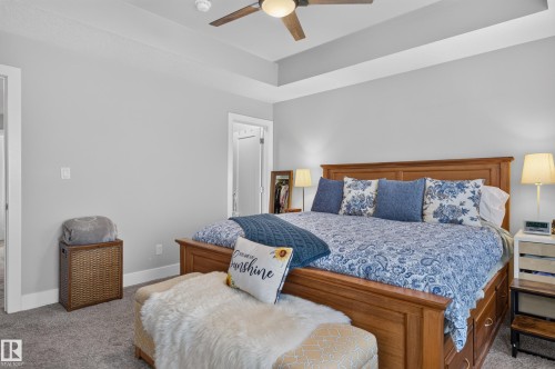 Room featuring a tray ceiling, neutral wall tones, neutral carpeting, and a ceiling fan with integrated lighting - 798 Berg Loop, Leduc, AB 