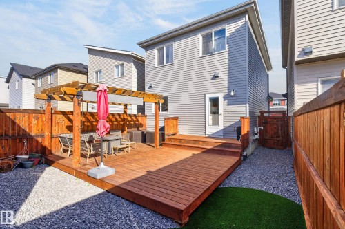 Multi-level wood deck featuring a built-in pergola, privacy fencing, and a gravel-surfaced yard area - 798 Berg Loop, Leduc, AB 