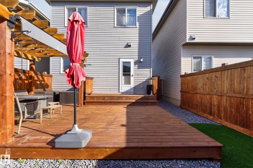 Multi-level wood deck featuring a timber-frame pergola, horizontal wood privacy fencing, and exterior lap siding - 798 Berg Loop, Leduc, AB 