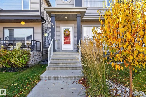 Front exterior featuring horizontal siding, a covered entryway with structural columns, concrete steps, and a glass-paneled front door - 798 Berg Loop, Leduc, AB 