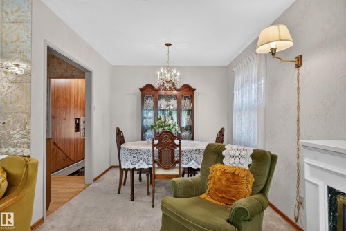 Carpeted living space with a wall-mounted sconce and a fireplace mantel - 14 Sonora Drive, St. Albert, AB 