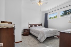 Light-colored carpeting, multiple windows with exterior scenery, and a ceiling fan with integrated lighting - 