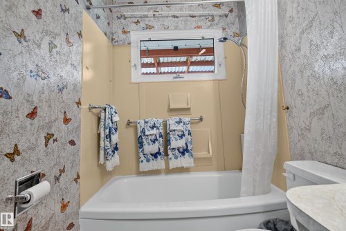 White bathtub with a handheld shower fixture, accented by a window above - 14 Sonora Drive, St. Albert, AB 