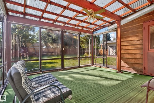 Screened sunroom featuring a corrugated translucent roof, wood beam construction, ceiling fan, and green striped flooring - 14 Sonora Drive, St. Albert, AB 