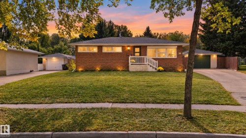 Brick exterior featuring white railings, a detached garage, an additional single-car garage, and a concrete driveway - 14 Sonora Drive, St. Albert, AB 