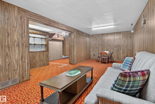 Wood-finish wall paneling throughout, built-in shelving, dropped ceiling with fluorescent lighting, and patterned carpeting - 14 Sonora Drive, St. Albert, AB 