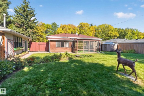 Expansive backyard featuring a manicured lawn, established landscaping, and a screened-in patio - 14 Sonora Drive, St. Albert, AB 