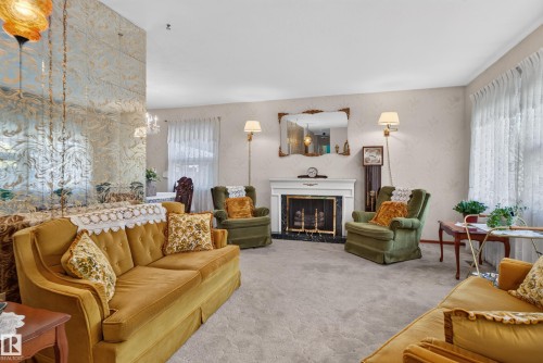 Fireplace with a white mantel and black surround, wall-to-wall carpeting, and floor-length window treatments - 14 Sonora Drive, St. Albert, AB 