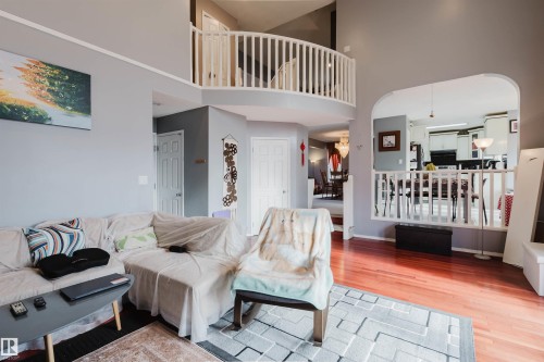 Vaulted ceilings, wood-finish flooring, arched entryway, and a mezzanine balcony with white balusters - 225 Heagle Crescent Nw, Edmonton, AB 