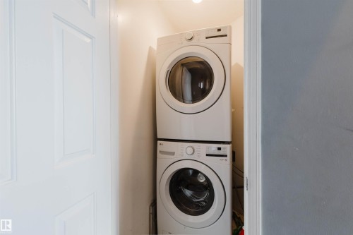 Laundry closet featuring stacked front-loading washer and dryer units - 225 Heagle Crescent Nw, Edmonton, AB 