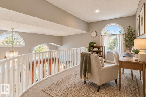 Open loft area featuring arched windows, white spindle balustrades, recessed lighting, and carpeted flooring - 225 Heagle Crescent Nw, Edmonton, AB 