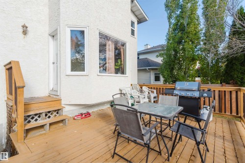 Elevated wood deck featuring vertical wood slat railings, wooden stair access, and stucco exterior finish - 225 Heagle Crescent Nw, Edmonton, AB 