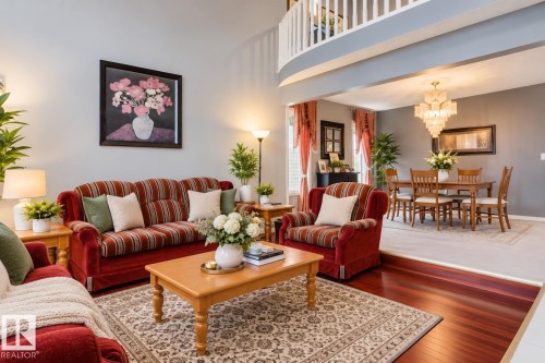 Vaulted ceilings, wood-finish flooring, tiered crystal chandelier, and a curved loft balcony railing - 225 Heagle Crescent Nw, Edmonton, AB 