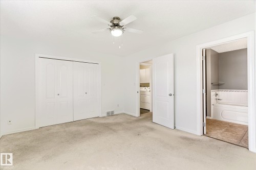 Wall-to-wall carpeting, bi-fold closet doors, ceiling fan with integrated lighting, and a full bathroom with a tub-shower combination - 2550 Rabbit Hill Road Nw, Edmonton, AB 