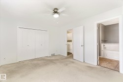 Wall-to-wall carpeting, bi-fold closet doors, ceiling fan with integrated lighting, and a full bathroom with a tub-shower combination - 