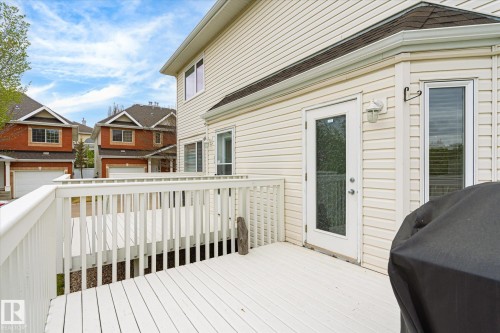 Expansive white wood deck with railing and direct access to the interior via a glass-paneled door - 2550 Rabbit Hill Road Nw, Edmonton, AB 