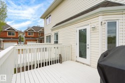 Expansive white wood deck with railing and direct access to the interior via a glass-paneled door - 