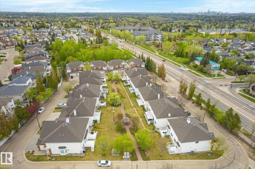 Aerial perspective of a neighborhood featuring multiple residential structures, mature trees, and paved roadways - 2550 Rabbit Hill Road Nw, Edmonton, AB 