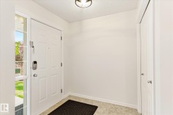 White paneled entry door with sidelite, light-colored tile flooring, and a flush-mount ceiling light fixture - 