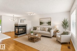 Hardwood-finish flooring, a two-sided fireplace with a tile surround, and large windows with blinds - 