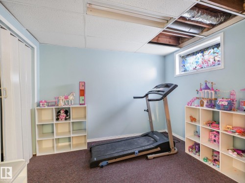 Recessed fluorescent lighting, drop ceiling, light blue painted walls, and an egress window - 7520 130 Avenue Nw, Edmonton, AB 