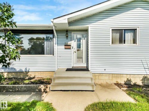 Light blue horizontal siding exterior with white trim - 7520 130 Avenue Nw, Edmonton, AB 