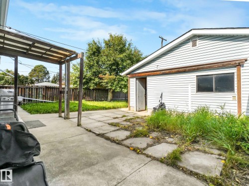 Detached structure with horizontal siding, concrete patio, concrete stepping stones, and a partial pergola - 7520 130 Avenue Nw, Edmonton, AB 