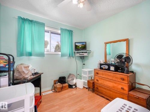 Wood-finish flooring with a ceiling fan light fixture - 7520 130 Avenue Nw, Edmonton, AB 