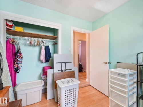 Built-in closet with a wood-finish shelf and hanging rod - 7520 130 Avenue Nw, Edmonton, AB 