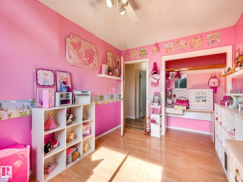 Wood-finish flooring with a light tone, ceiling fan with integrated lighting, and built-in shelving - 7520 130 Avenue Nw, Edmonton, AB 