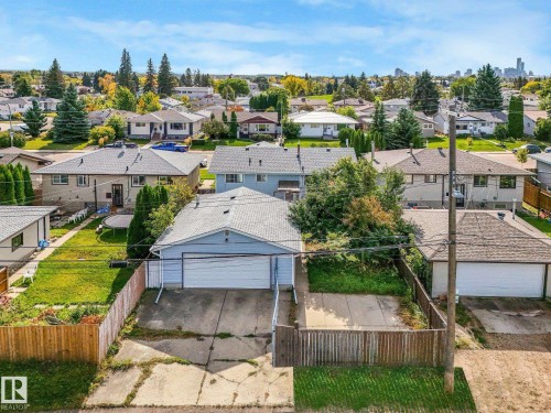 Residential property with a single-story structure, a paved driveway, a two-car attached garage, and a fenced backyard - 7520 130 Avenue Nw, Edmonton, AB 